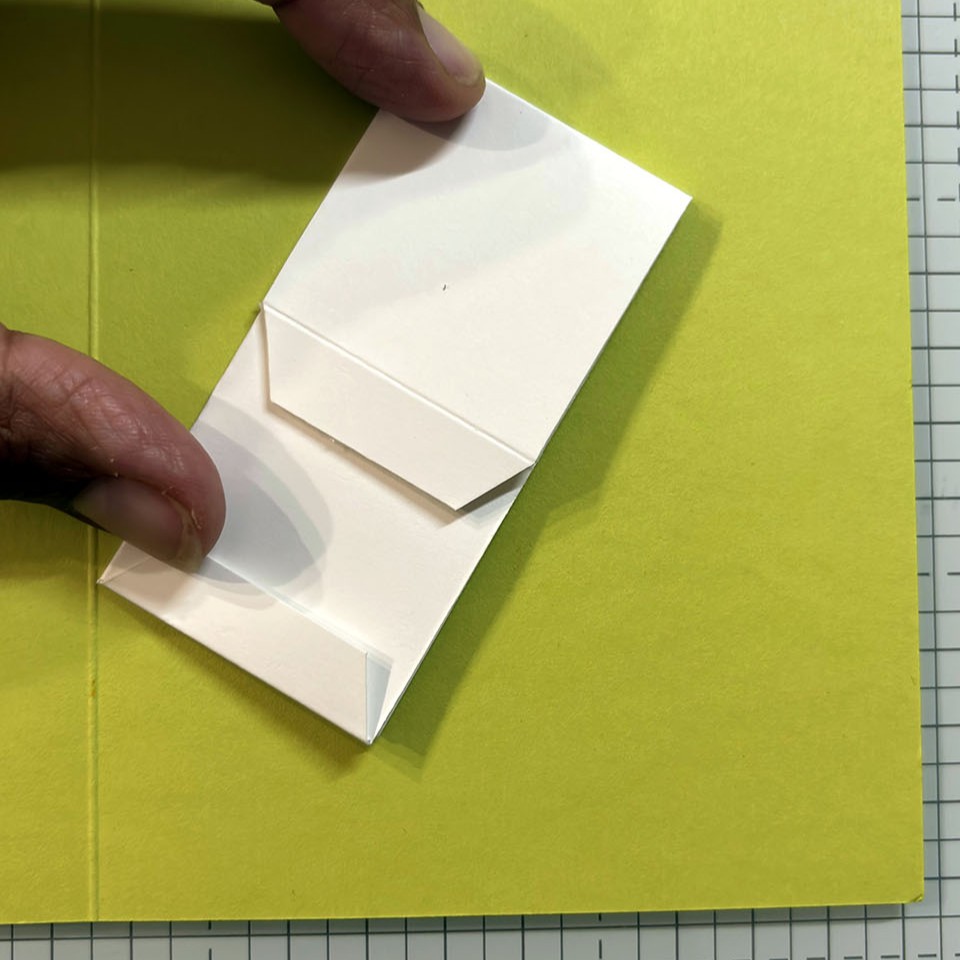 Étape 4 carte popup plateforme - mécanisme plié posé à plat sur le fond de carte vert