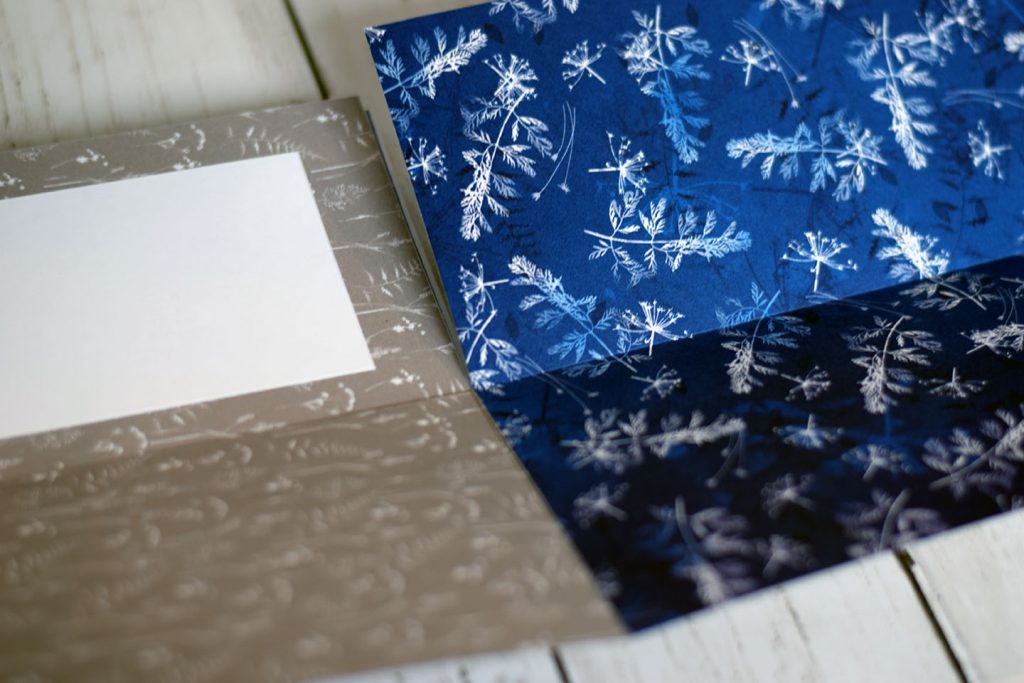 Page pliage escargot pour mini-album origami — réserve blanche centrale entourée de papiers design bleu nuit