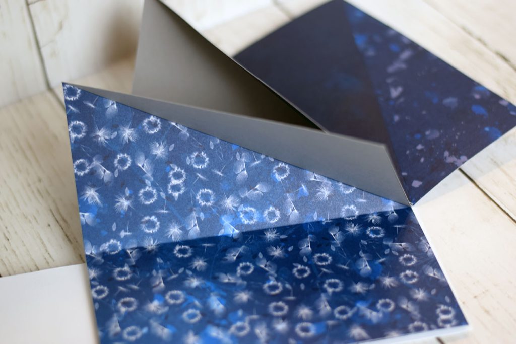 Pliage superposition origami déplié en éventail — papier design motif étoiles bleu nuit et blanc