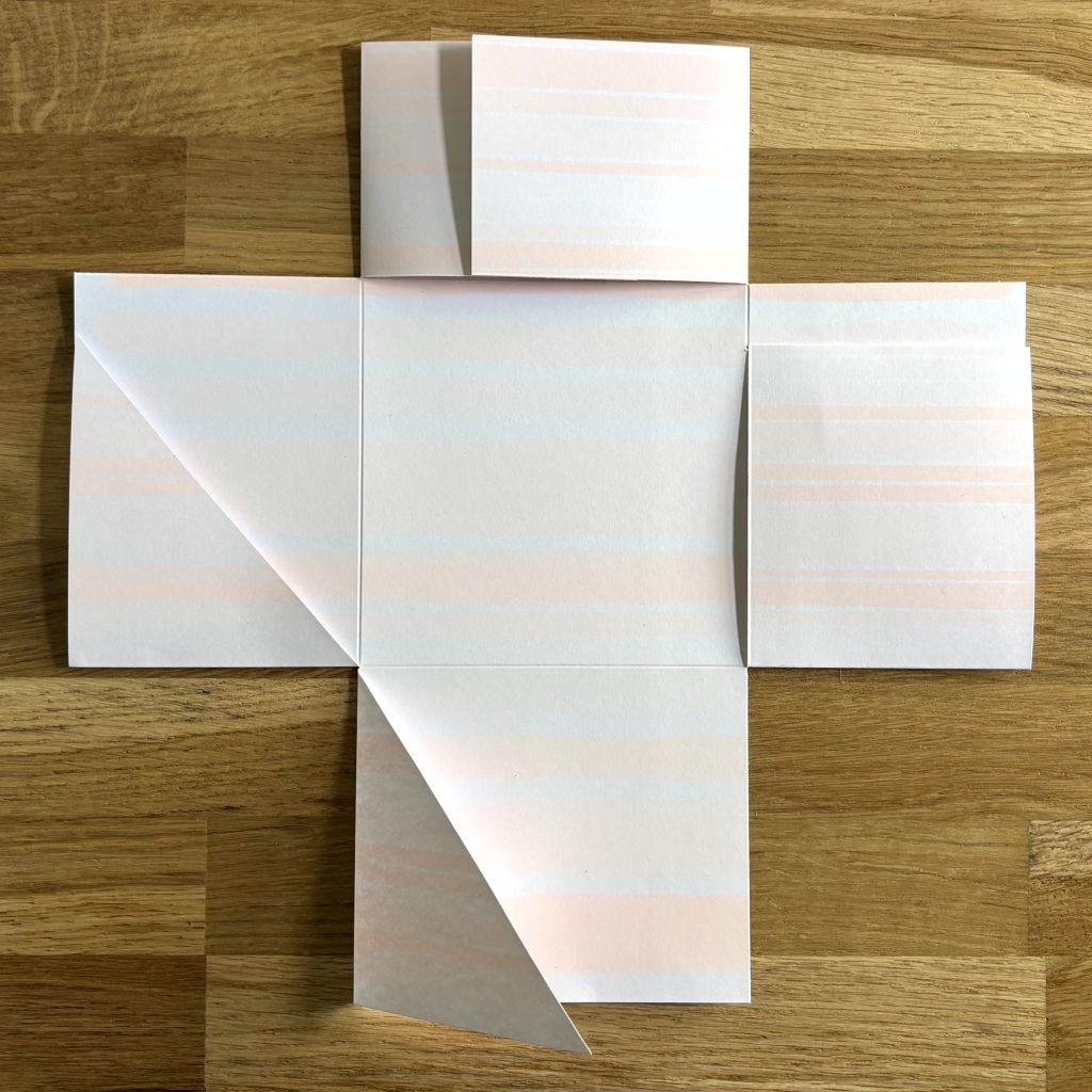mini album en cours de pliage avec formes en croix sur papier
