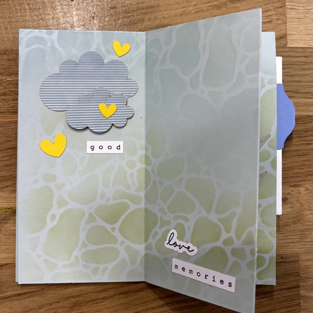 mini album ouvert avec décoration nuages et petits cœurs
