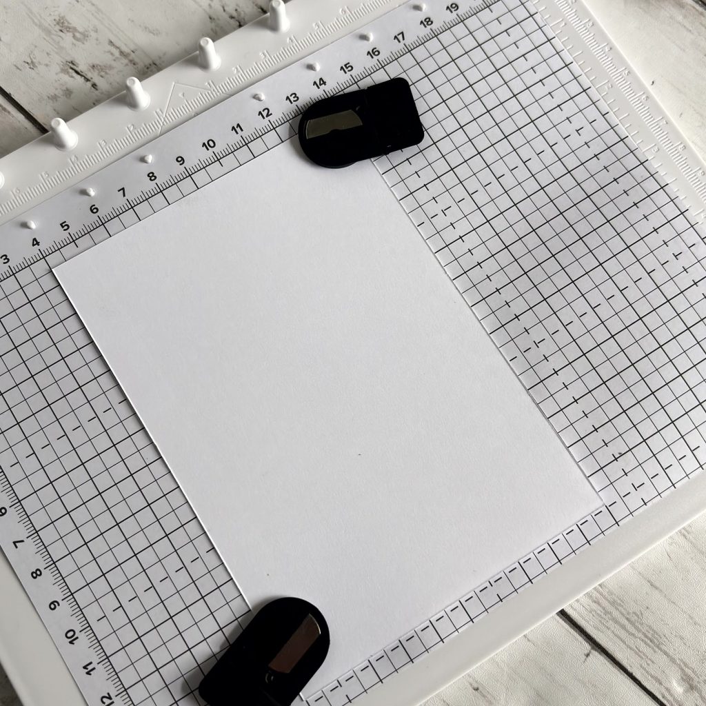 Papier blanc fixé avec les aimants sur le positionneur d'images Stampin'Up! avant tamponnage