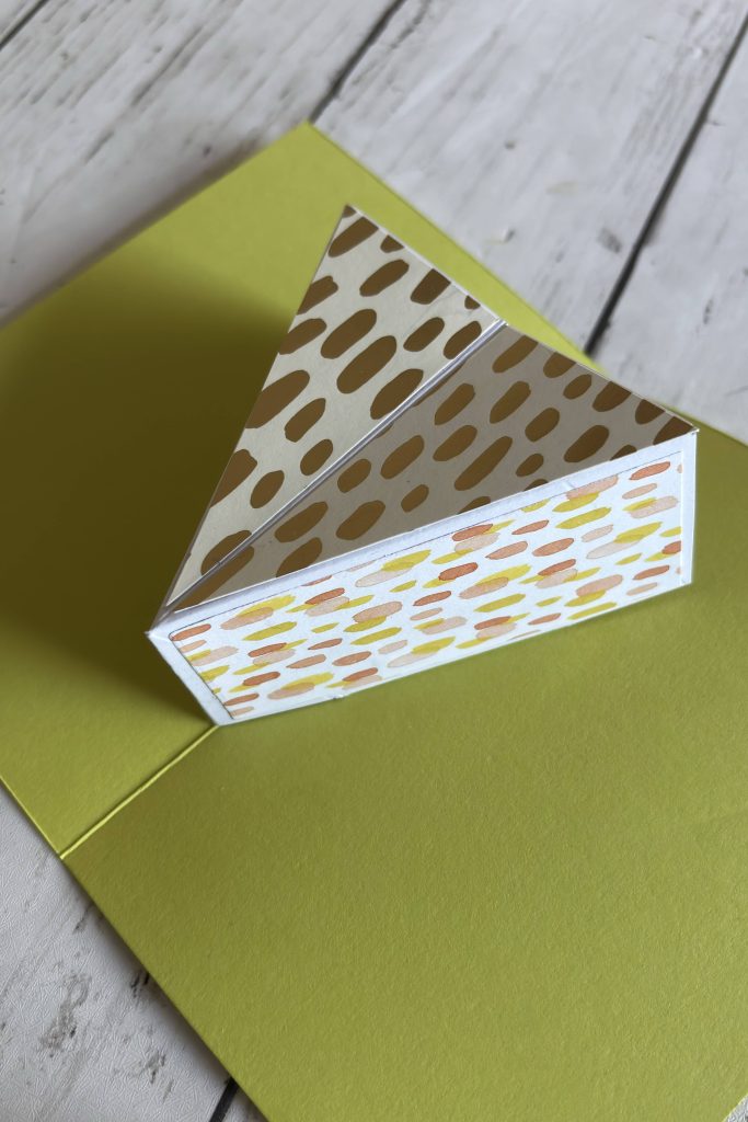 Carte pop-up gâteau refermée sur fond vert anis
