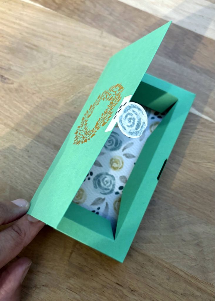 Crée une languette de fermeture à l'aide d'une perforatrice ou de ciseaux, puis colle-la sur le couvercle.