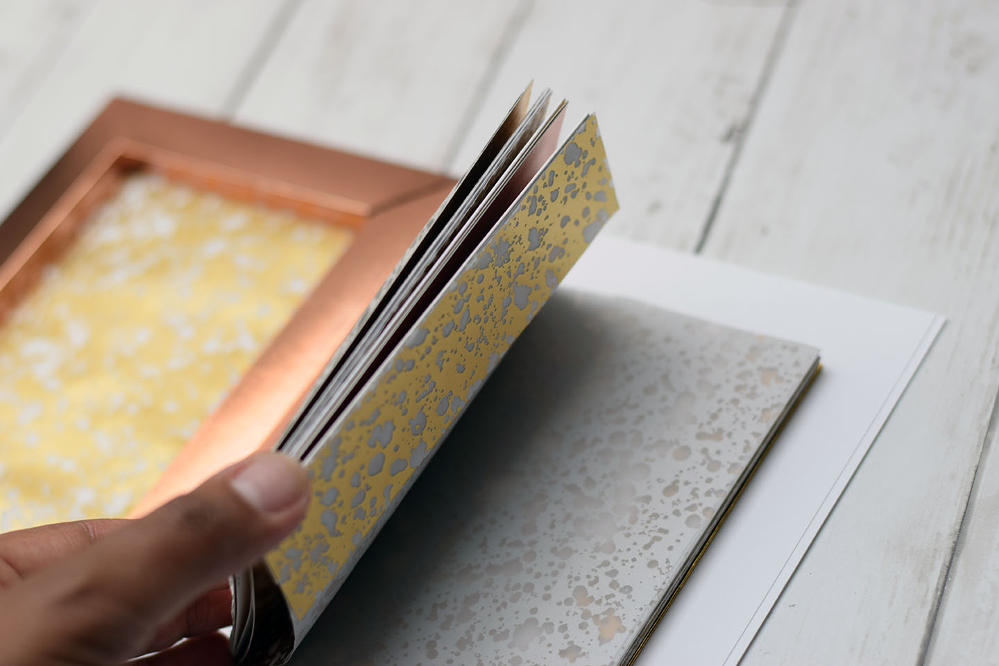Album accordéon ouvert avec couverture cadre cuivrée et pages mouchetées