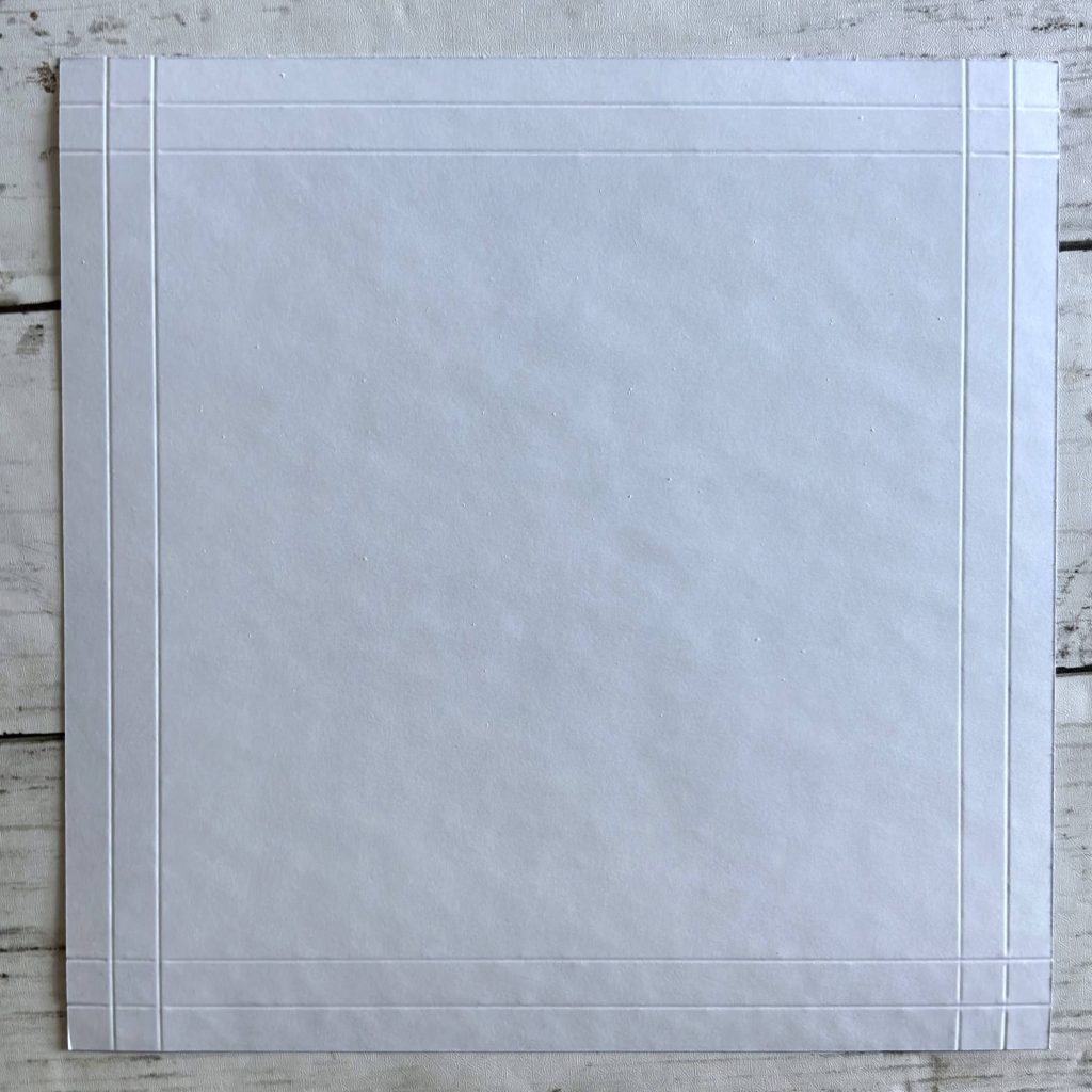 Découpe un morceau uni ou à motifs de 21x21 cm pour le cadre. Plie (soigneusement) à 1 et 2 cm sur les 4 côtés.