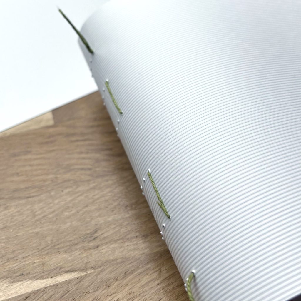 étape de couture des cahiers en reliure cousue main sans machine