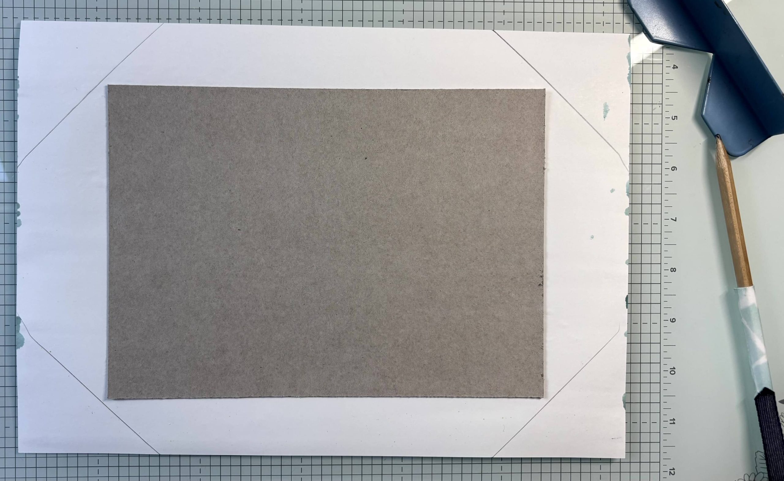 Coins du papier coupés en biais à 45° avant de rabattre sur le carton de couverture d'album