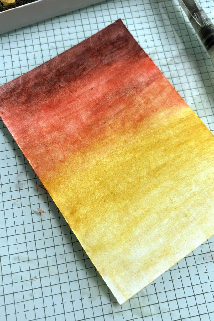 Fond dégradé rouge-jaune réalisé avec pastels secs Stampin'Up! dilués à l'eau au pinceau