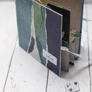 Intérieur album carrousel popup ouvert avec pages qui se déploient en accordéon tons bleu ardoise vert mousse et taupe