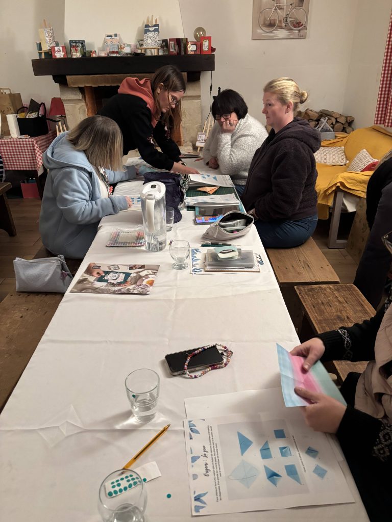 Groupe de participantes en atelier origami guidé lors du week-end scrap 2026 à La Bergerie de Brie