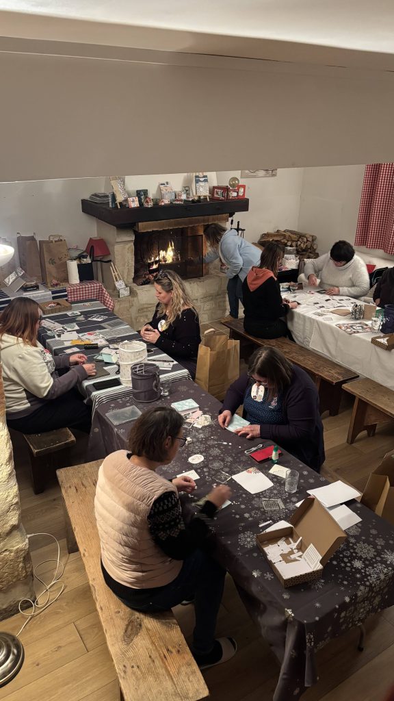 Participantes en plein atelier scrapbooking au coin du feu à La Bergerie, ambiance cosy du week-end scrap
