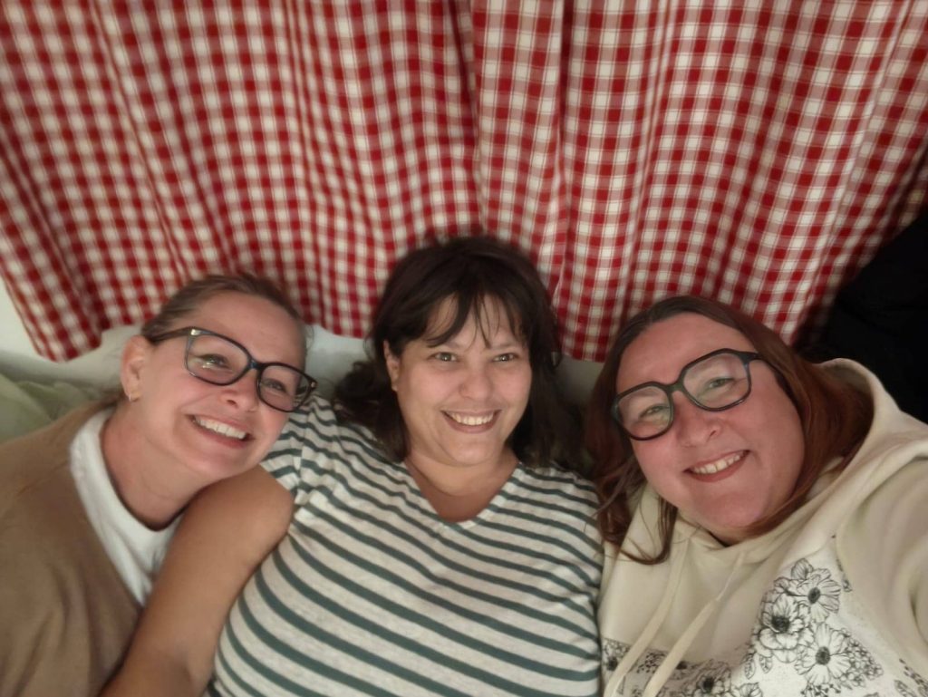 Trois participantes souriantes lors du week-end scrap Scrapbook'Nine à La Bergerie, ambiance bonne humeur
