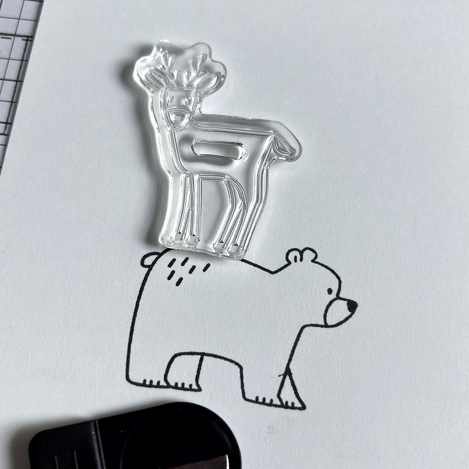 Positionnement du tampon transparent du cerf au-dessus de l'ours pour créer une scène avec le positionneur d'images Stampin'Up!