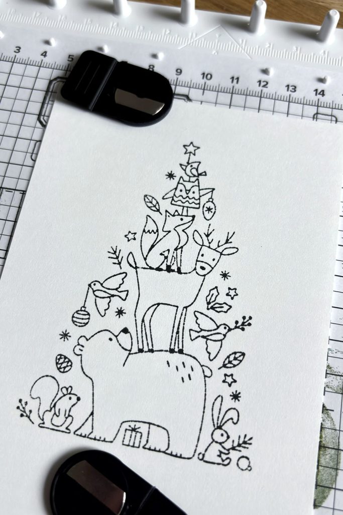 Premier passage de tamponnage de la scène de sapin et animaux avec le positionneur d'images Stampin'Up!