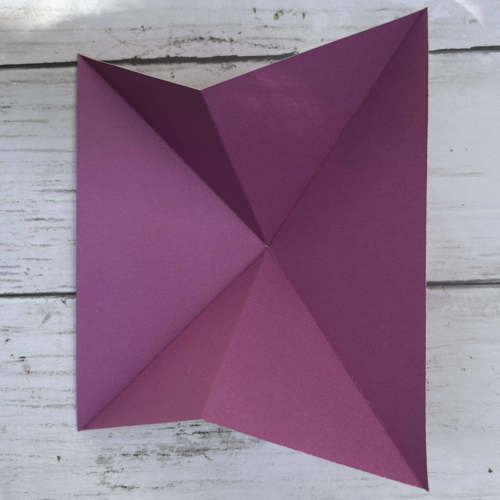 Papier violet plié formant triangle pointe ouverte