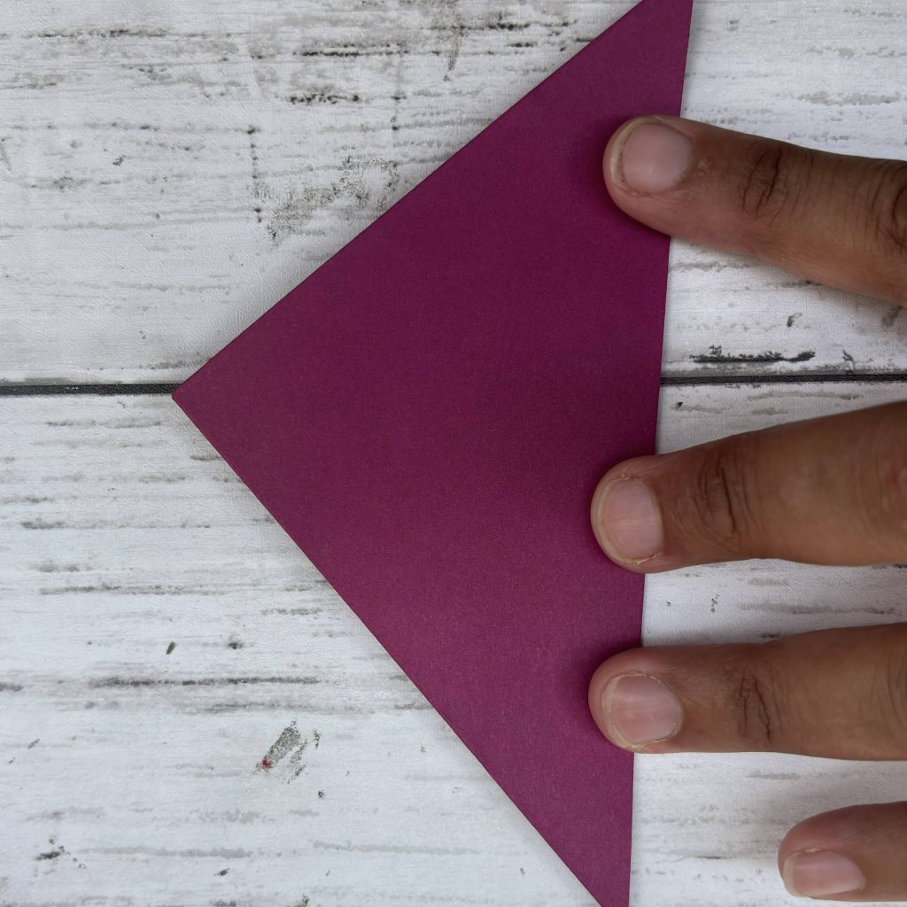 Pliage papier violet formant pointe triangle serré