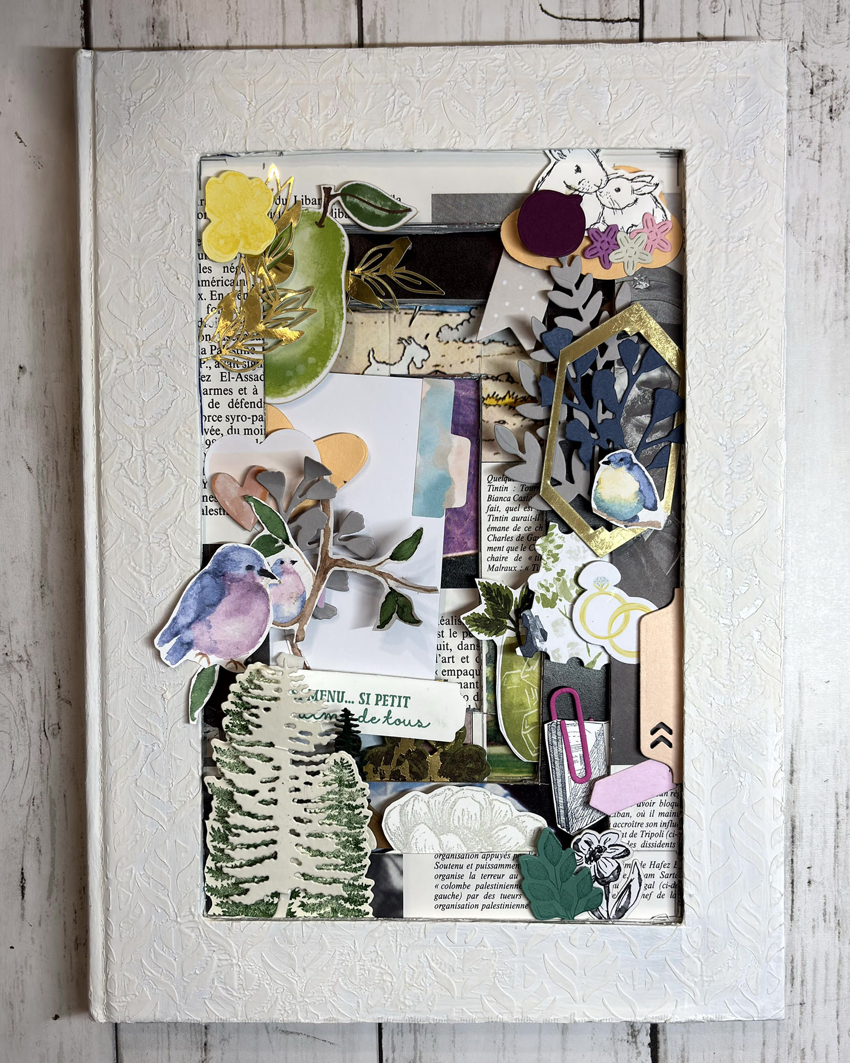 Intérieur du tunnel book décoré avec sapins, oiseaux et fleurs en papier