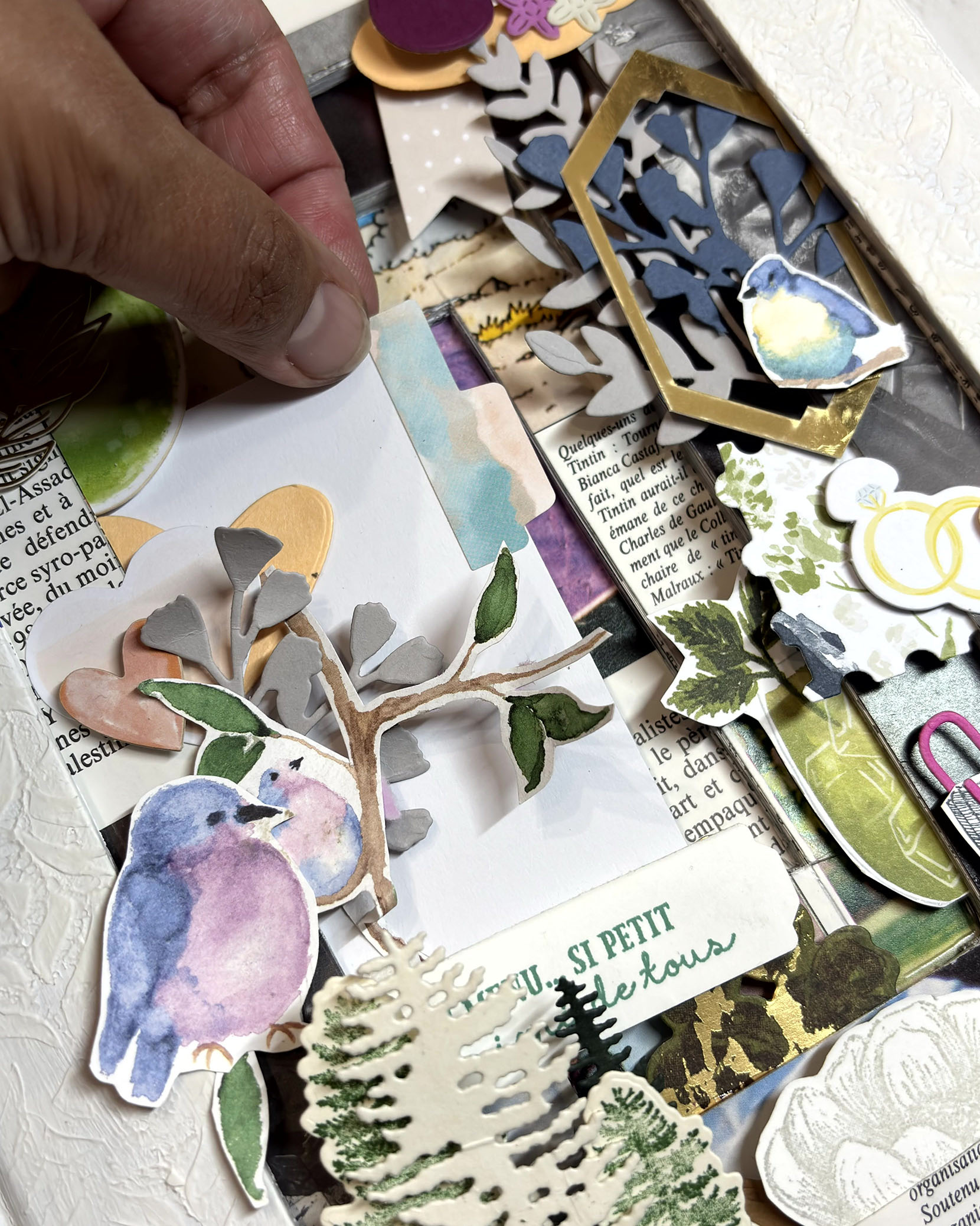 Main en train de positionner un oiseau en papier dans le tunnel book