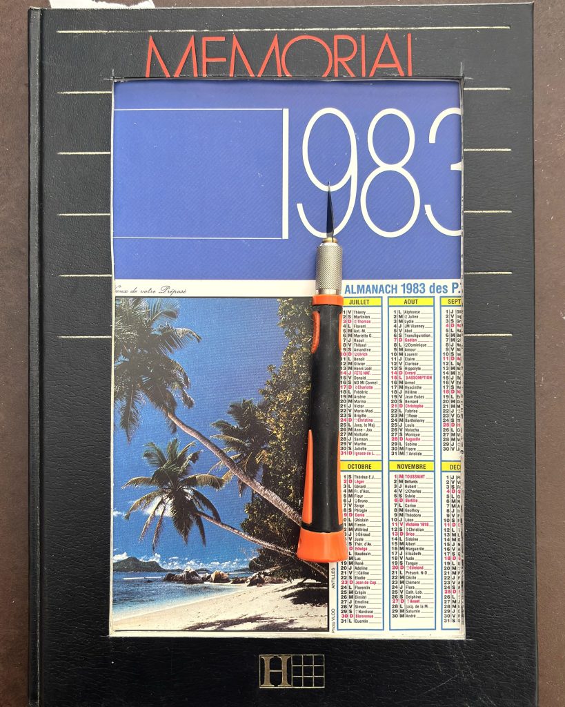 Couverture intérieure du livre avec calendrier 1983 et cutter posé dessus pour la découpe